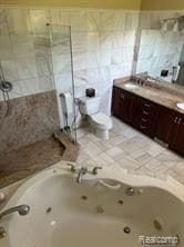 5238 Windmill Dr, Troy, MI 48085 - full bath featuring tiled shower, toilet, double vanity, and a jetted tub