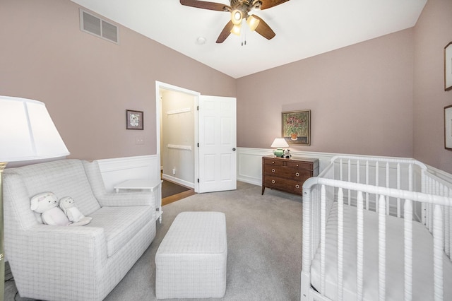 bedroom featuring carpet, visible vents, a wainscoted wall, and ceiling fan