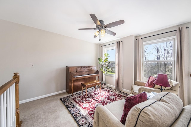 living area with ceiling fan, baseboards, carpet, and a wealth of natural light