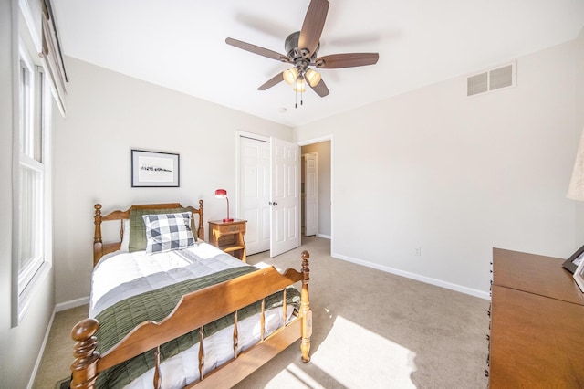 bedroom with light carpet, a closet, baseboards, and visible vents