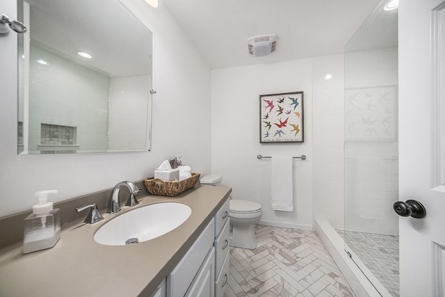 bathroom featuring a tile shower, vanity, recessed lighting, toilet, and baseboards