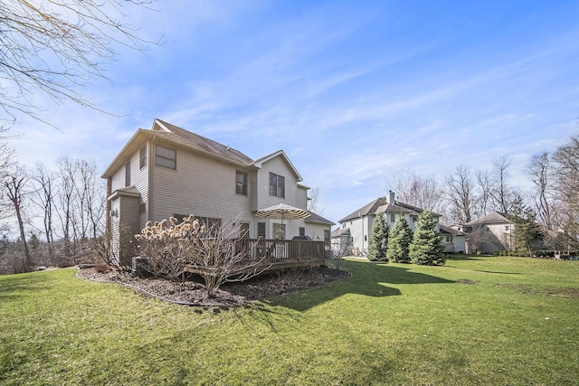 view of side of property featuring a wooden deck and a lawn