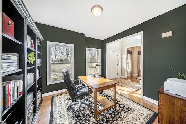 home office featuring baseboards and light wood-type flooring