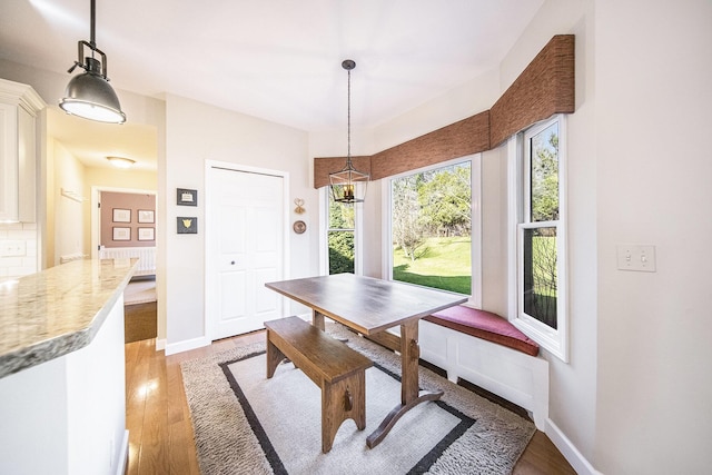 dining room with light wood-type flooring and baseboards
