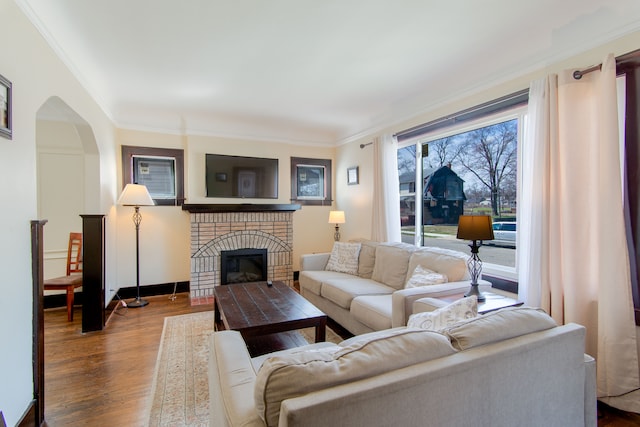16890 Monica St, Detroit, MI 48221 - living room with ornamental molding, arched walkways, wood finished floors, and a fireplace