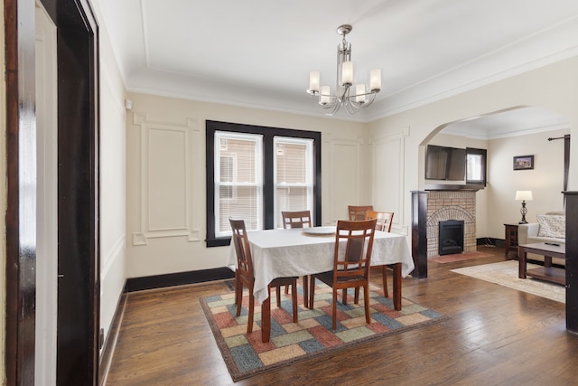 16890 Monica St, Detroit, MI 48221 - dining room featuring an inviting chandelier, arched walkways, ornamental molding, and dark wood finished floors