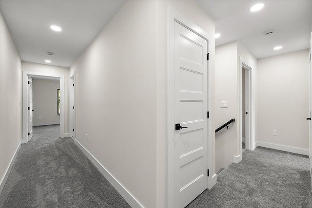 hallway with recessed lighting, baseboards, and dark carpet