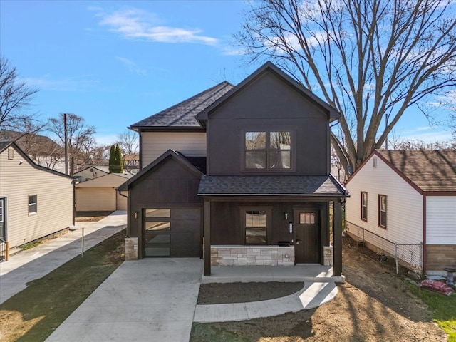 view of front of home with a garage, covered porch, roof with shingles, stone siding, and driveway