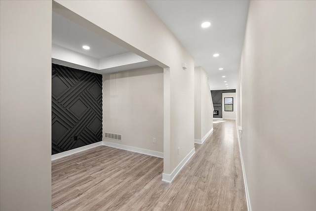 corridor featuring recessed lighting, visible vents, light wood-type flooring, and baseboards
