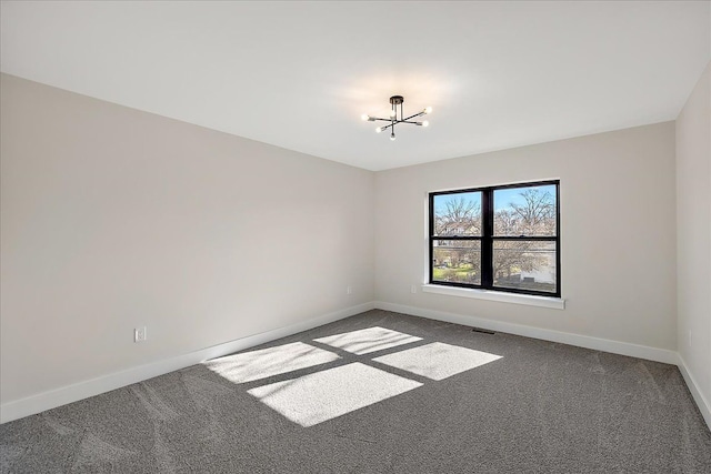 empty room with a notable chandelier, baseboards, and carpet floors
