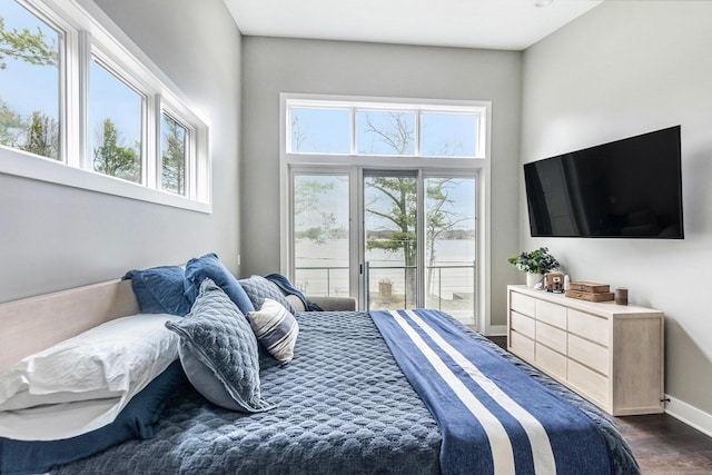 bedroom with dark wood-style flooring, multiple windows, access to exterior, and baseboards