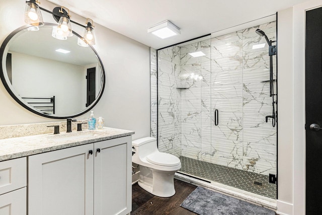 full bathroom featuring an inviting chandelier, a shower stall, vanity, toilet, and wood finished floors