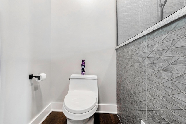 bathroom with baseboards, toilet, and wood finished floors