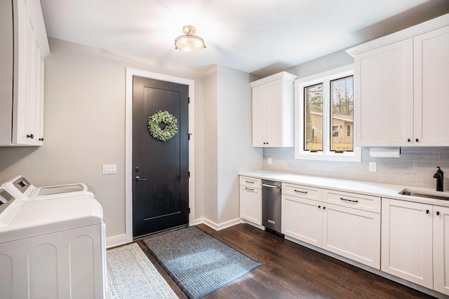 laundry area featuring separate washer and dryer, dark wood-style flooring, a sink, baseboards, and cabinet space