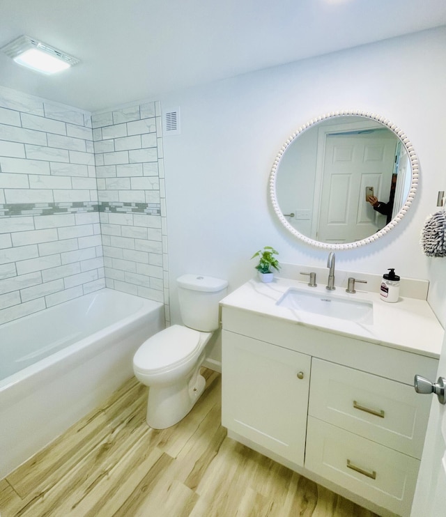 bathroom featuring vanity, visible vents, toilet, and wood finished floors