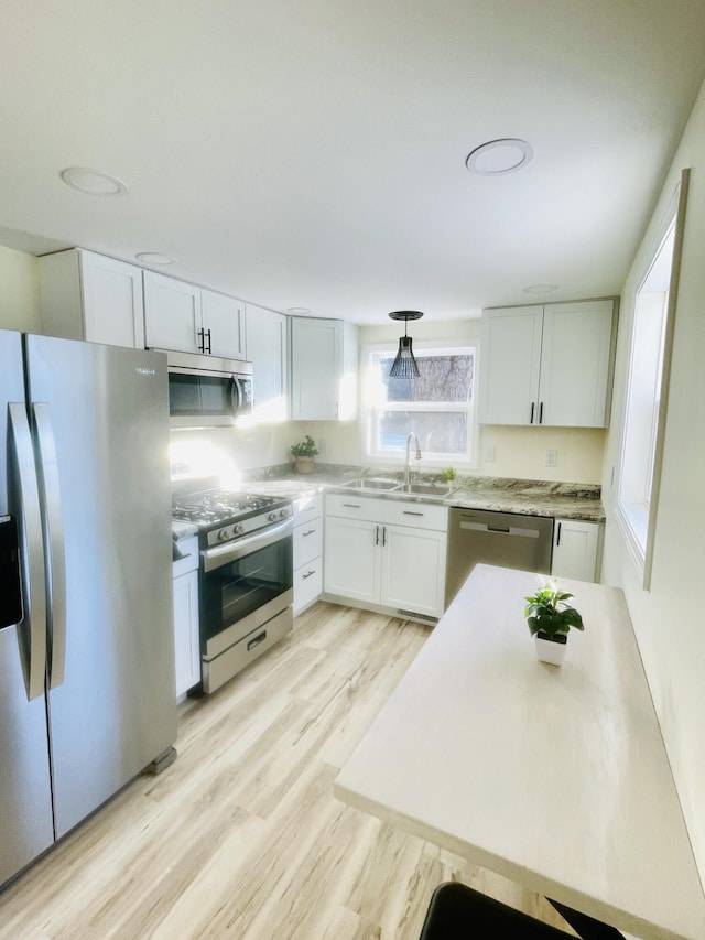 kitchen with light countertops, a sink, white cabinetry, and stainless steel appliances