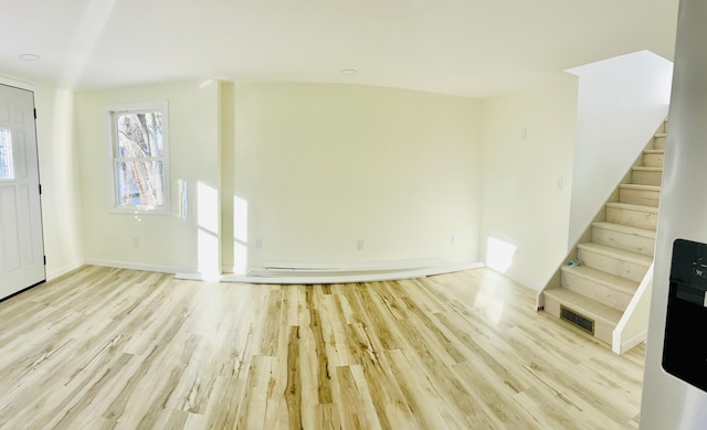 entrance foyer featuring wood finished floors, visible vents, and stairway