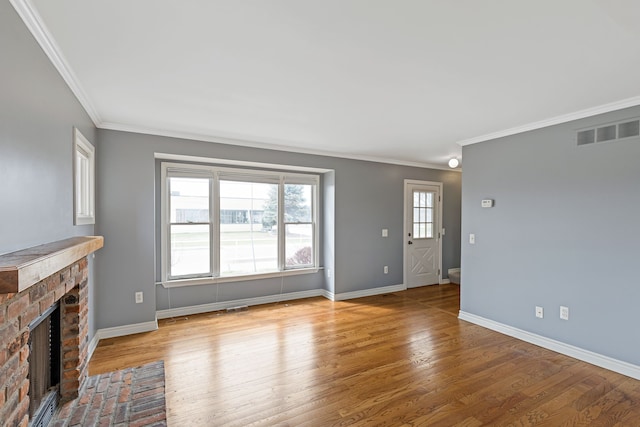 1053 Woodward Hts, Ferndale, MI 48220 - unfurnished living room with wood finished floors, visible vents, ornamental molding, and a brick fireplace