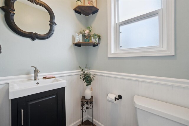 739 Gasper St, Chesaning, MI 48616 - half bathroom with toilet, vanity, and a wainscoted wall