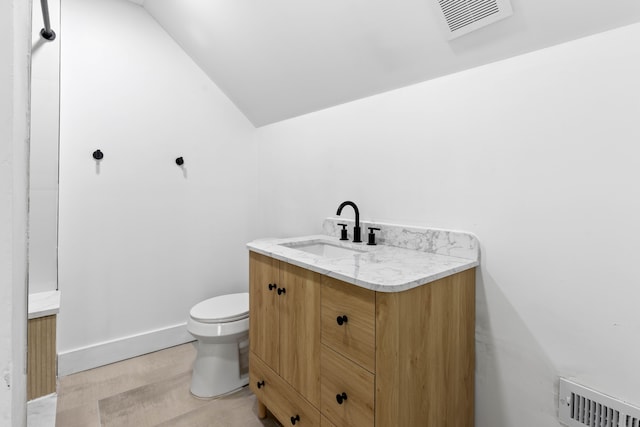 1651 Edison St, Detroit, MI 48206 - bathroom featuring vanity, lofted ceiling, toilet, wood finished floors, and baseboards