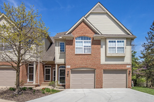 view of front of house with roof with shingles, concrete driveway, a garage, and brick siding