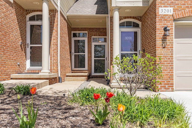 property entrance featuring brick siding, roof with shingles, and covered porch