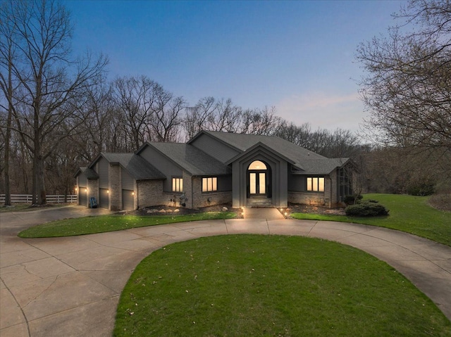 1194 Eagle Nest, Milford, MI 48381 - view of front facade featuring curved driveway, a front lawn, french doors, brick siding, and an attached garage