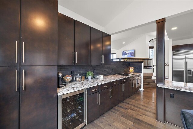 1194 Eagle Nest, Milford, MI 48381 - kitchen with built in appliances, wine cooler, dark wood-style flooring, tasteful backsplash, and dark brown cabinets