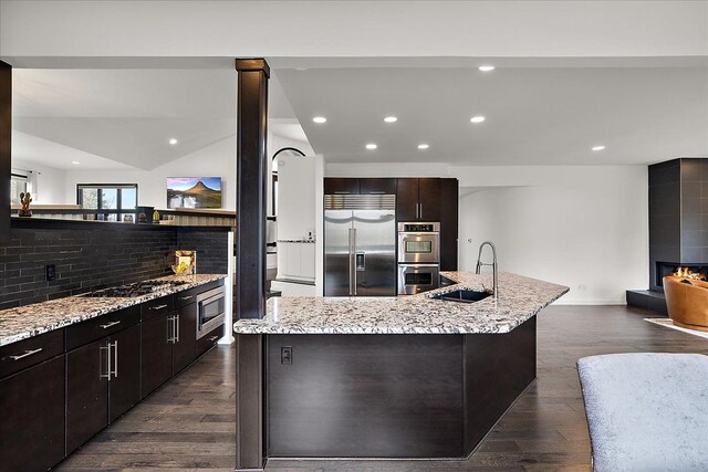 1194 Eagle Nest, Milford, MI 48381 - kitchen featuring built in appliances, a sink, a fireplace, backsplash, and recessed lighting