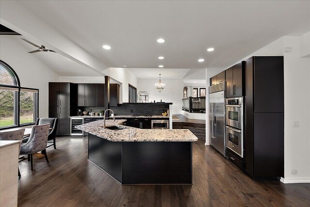 1194 Eagle Nest, Milford, MI 48381 - kitchen featuring wine cooler, appliances with stainless steel finishes, a chandelier, recessed lighting, and decorative backsplash