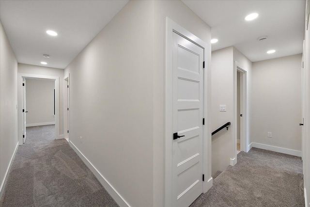 hallway with carpet flooring, baseboards, an upstairs landing, and recessed lighting