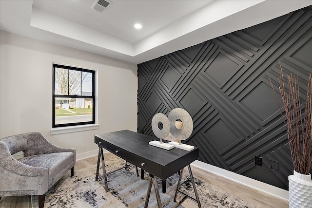 office with light wood-style flooring, baseboards, and visible vents