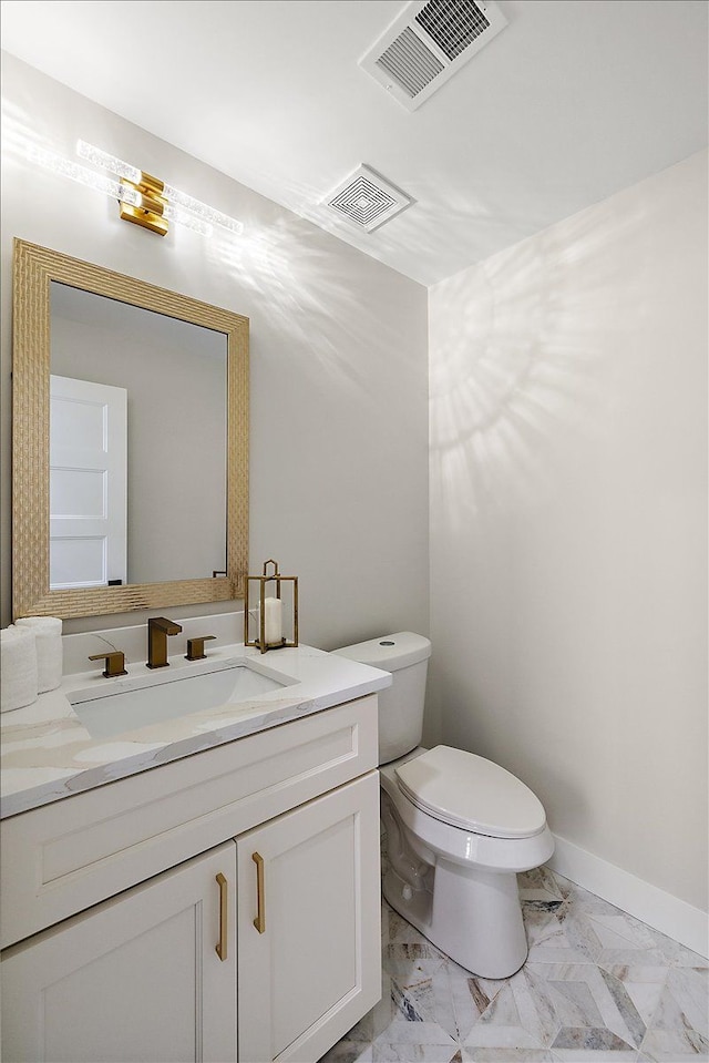 half bath with vanity, visible vents, marble finish floor, and toilet