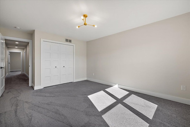 unfurnished bedroom with a chandelier, visible vents, baseboards, and dark carpet