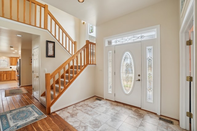 foyer featuring baseboards, recessed lighting, light wood-style floors, and stairs