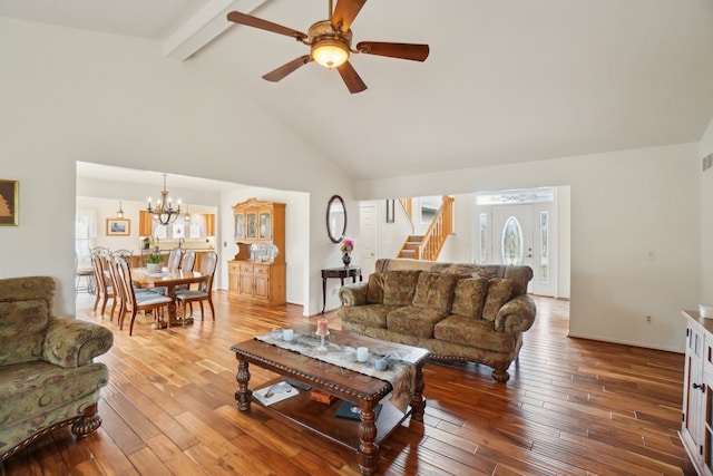 living area with beamed ceiling, high vaulted ceiling, hardwood / wood-style floors, and stairs