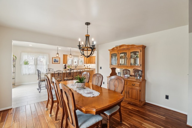dining area with a chandelier, hardwood / wood-style floors, and baseboards