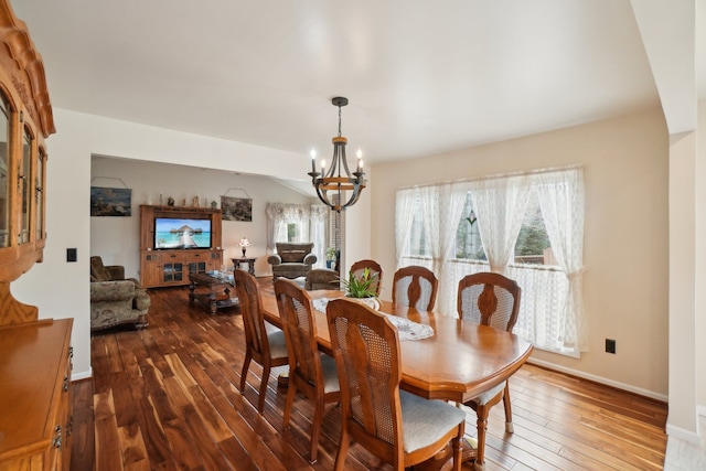 dining room featuring hardwood / wood-style floors, a notable chandelier, baseboards, and a wealth of natural light