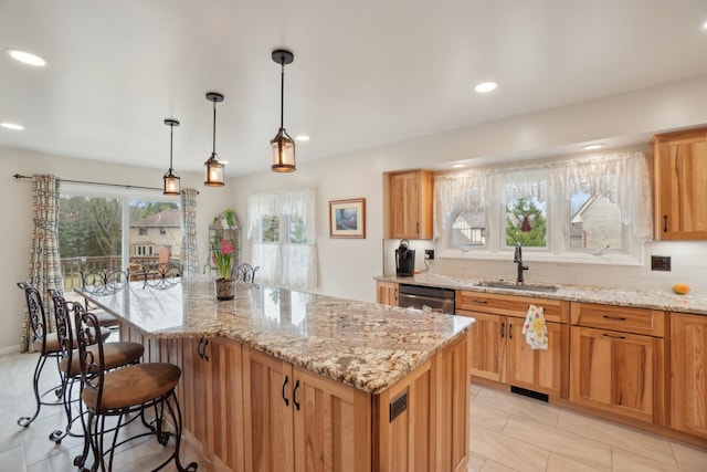 kitchen with light tile patterned floors, a center island, light stone counters, a sink, and a breakfast bar area