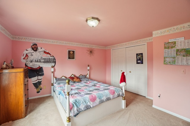 bedroom with light carpet, baseboards, and a closet