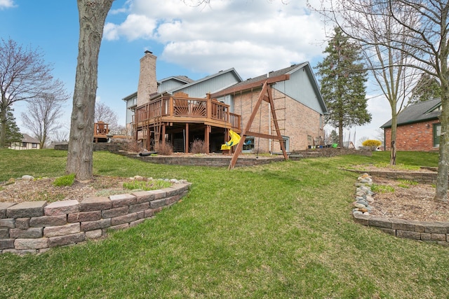 back of property with a chimney, stairway, brick siding, a deck, and a lawn