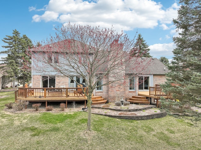 rear view of house with brick siding, a deck, and a lawn