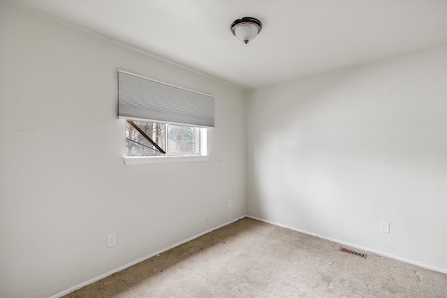 spare room with visible vents, baseboards, and carpet