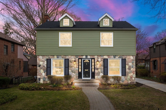 view of front of property featuring a yard and stone siding