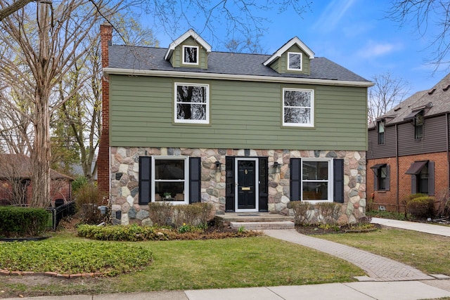 view of front of property with stone siding, a chimney, and a front lawn