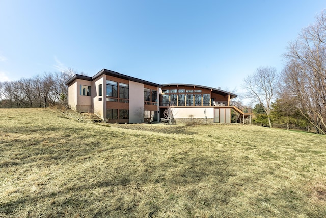 10485 Hadley Rd, Gregory, MI 48137 - rear view of property featuring stairs, stucco siding, a wooden deck, and a lawn