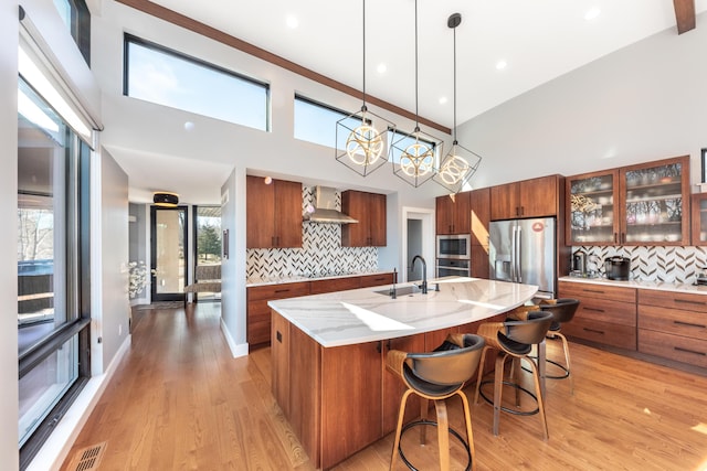 10485 Hadley Rd, Gregory, MI 48137 - kitchen with visible vents, a sink, wall chimney range hood, appliances with stainless steel finishes, and brown cabinets