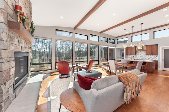 10485 Hadley Rd, Gregory, MI 48137 - living room with a wealth of natural light, light wood-style floors, a fireplace, beamed ceiling, and a towering ceiling