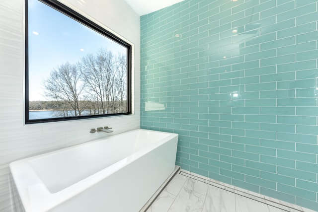 10485 Hadley Rd, Gregory, MI 48137 - bathroom featuring a freestanding bath, marble finish floor, and tile walls