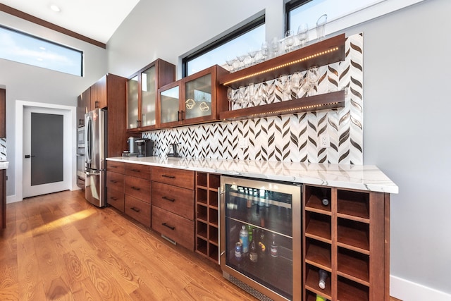 10485 Hadley Rd, Gregory, MI 48137 - bar featuring freestanding refrigerator, light wood-type flooring, bar area, decorative backsplash, and beverage cooler